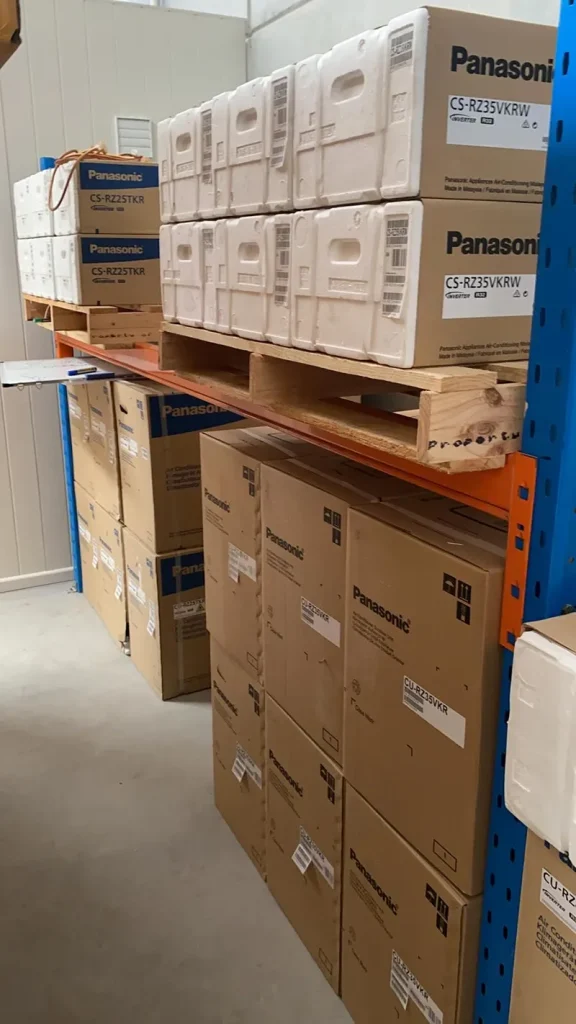 Actron Air stock stacked along a narrow warehouse aisle