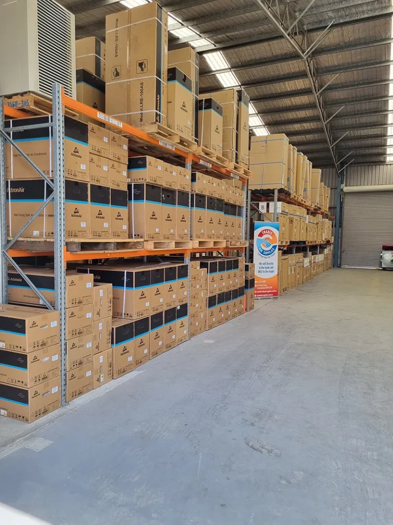 Pallets of boxed air conditioning units stacked along a warehouse aisle