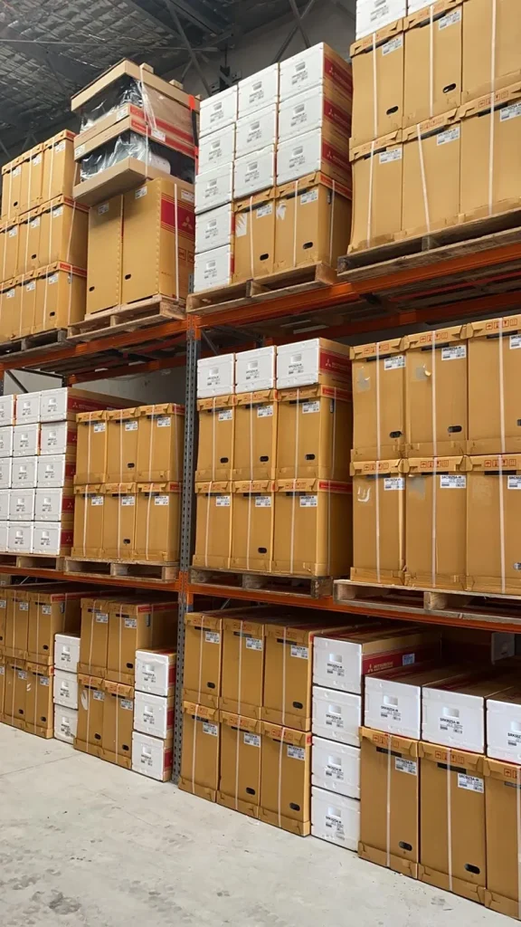 Panasonic air conditioning units stacked on warehouse racking